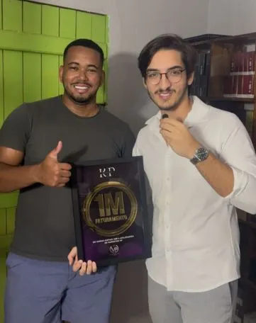 Parceiro da KP segurando a Placa de Faturamento 1M ao lado de consultor da KP